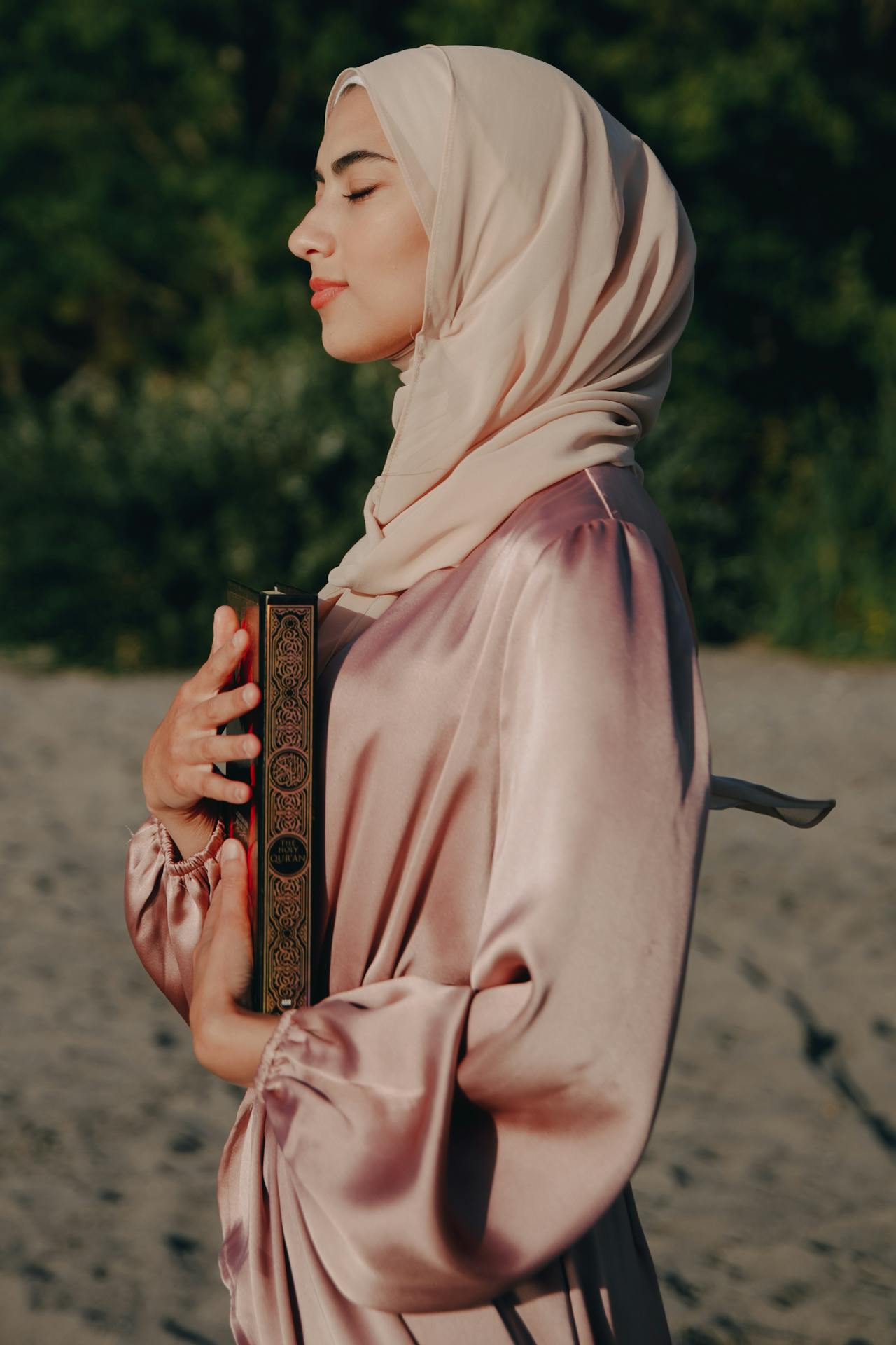 muslim woman holding quran on the beach